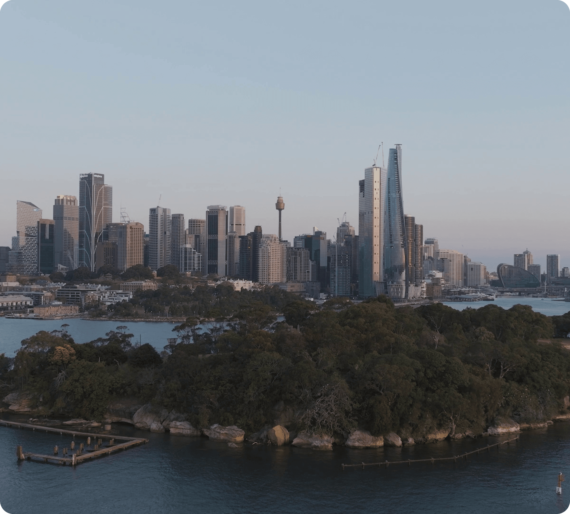 A panoramic view of the city skyline from a high vantage point, showcasing tall buildings against a clear blue sky.